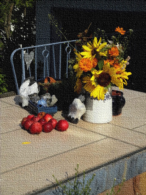 Rote Äpfel und Sonnenblumenblüten am Hauseingang