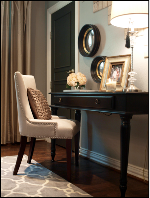 The black door enhances the black desk and round mirror frames.