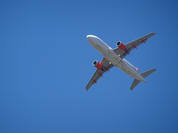Flugzeug am blauen Himmel von unten fotografiert