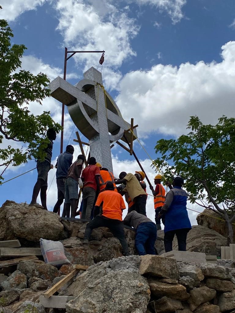Eine Gruppe Männer auf einem Hügel in Dodoma, die ein Missionskreuz errichten.