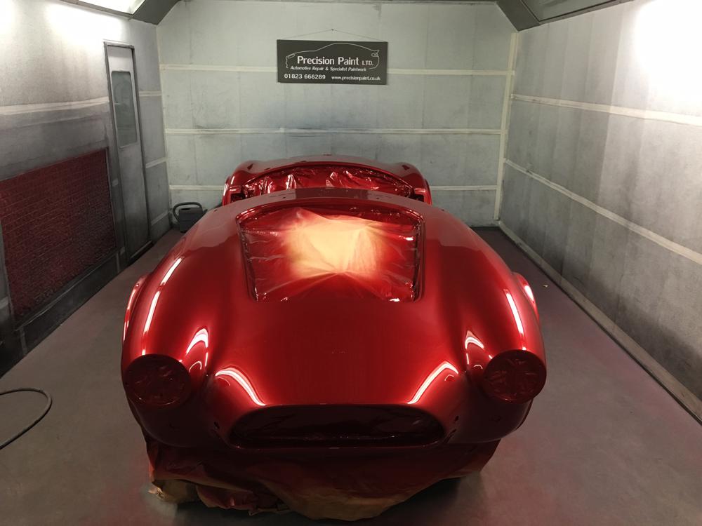 Front view of red Hawke Cobra shell in spray room, with coat of red paint, Precision Paint Wellington