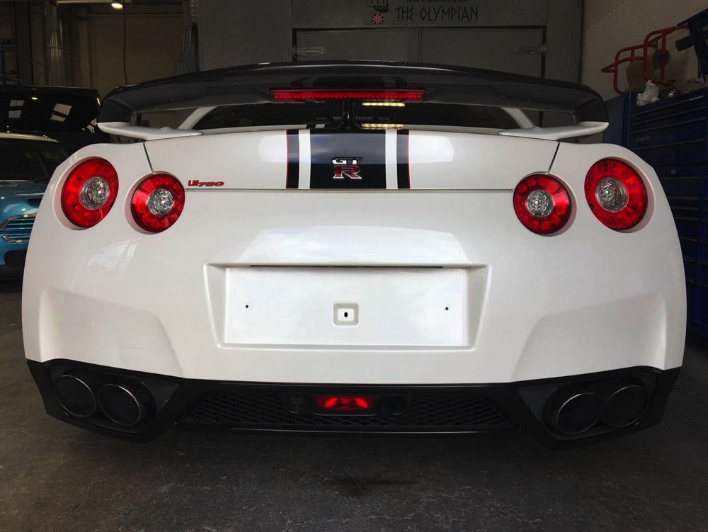 Back view of white Nissan GTR LM750 in workshop