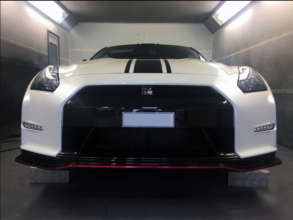 Front view of white Nissan GTR LM750 in workshop