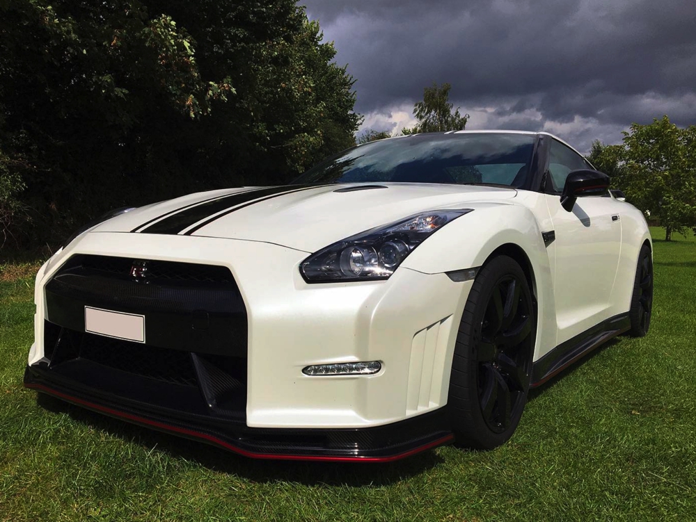 Side view of white Nissan GTR LM750 in field