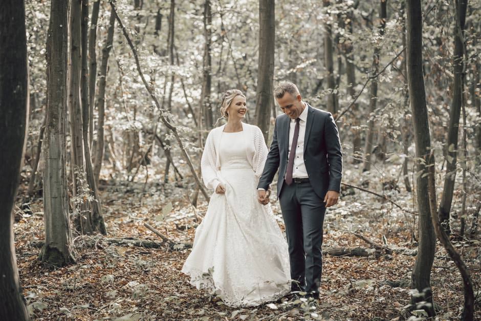 Brautpaar läuft Hand in Hand durch den Wald - Hochzeitsfotograf Rheinhessen