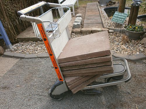Acht 50x50cm große Terrassenplatten werden zum neuen Fundament für die Bank