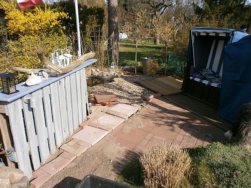 Die Platten und Pflastersteine wurden entlang der Holzwand verlegt