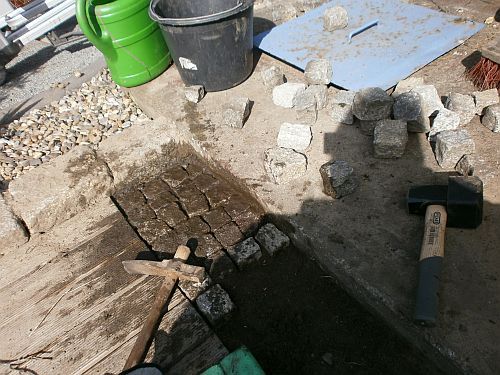 Die noch vorhandenen Lücken werden mit zahlreichen Gehwegsteinen gepflastert