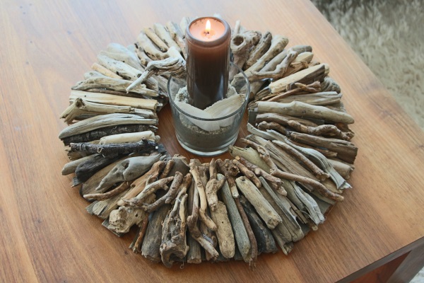 Fertige Tischdeko mit Kerze im braunen Schwemmholzkranz.