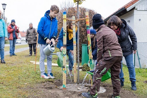 Kraiburg - Bund Naturschutz und Bürgermeisterin Petra Jackl goßen das Bäumchen mit den Kindern an. ©Erwin Wolf