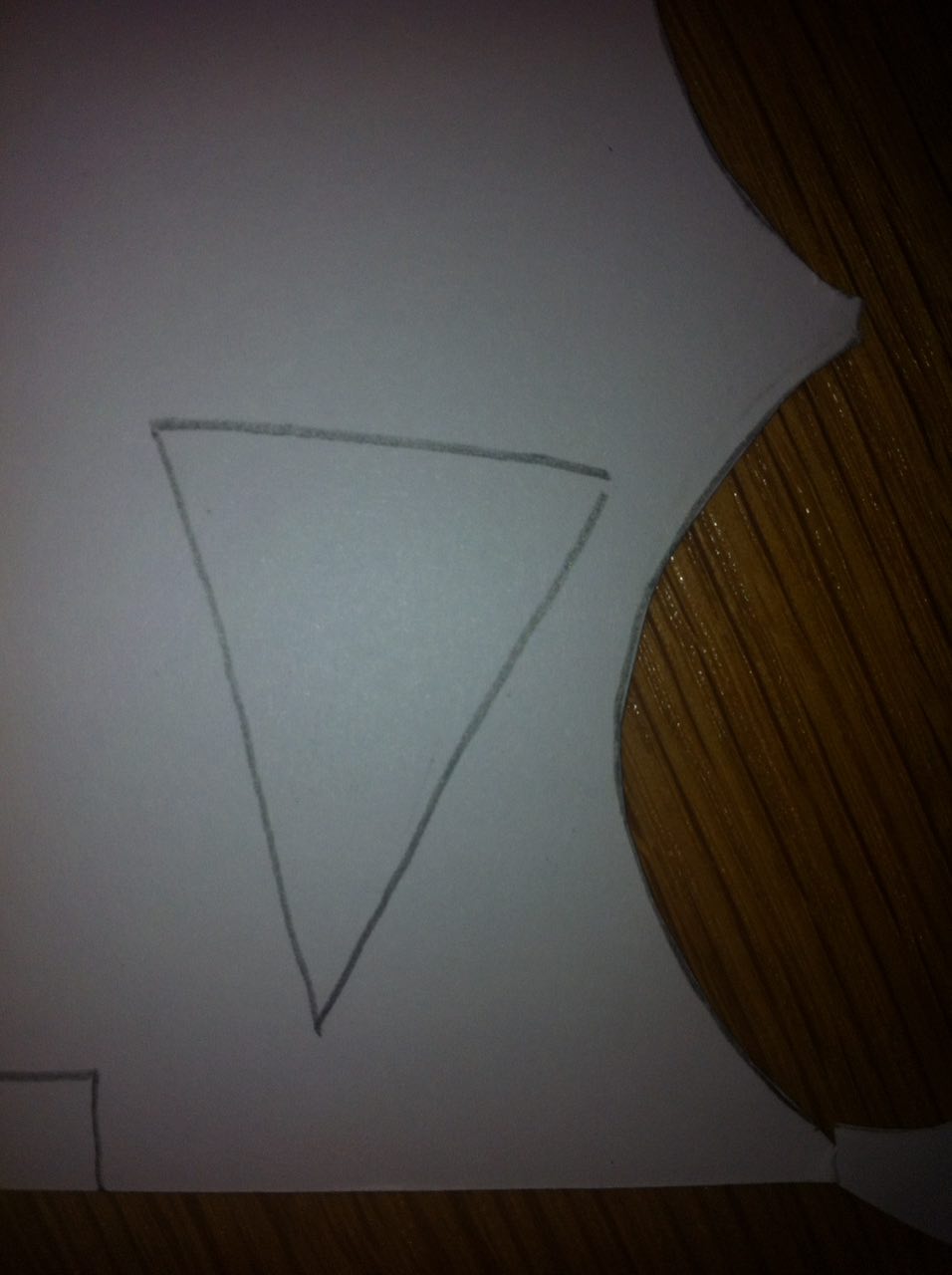 Dessine un triangle sur la feuille blanche pour faire le nez et deux petits rectangles pour les sourcils.
