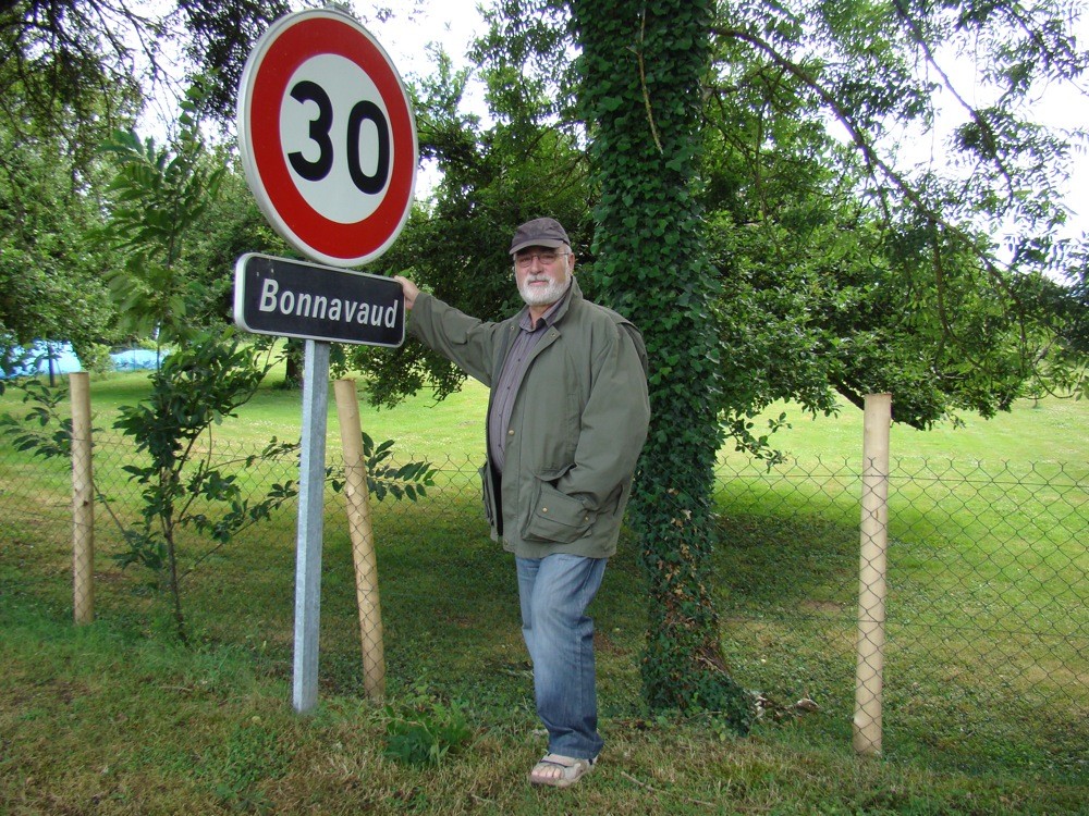 Hervé Bonnavaud devant la pancarte à l'entrée du hameau