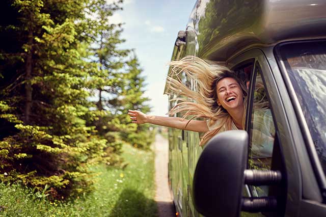 Wohnmobile zur Miete Frau jubelt aus Wohnmobil 2026