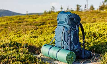 Isomatte an Rucksack auf Grashügel 2026