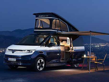 VW T7 California mit Markise und Campingmöbeln bei Nacht 2026