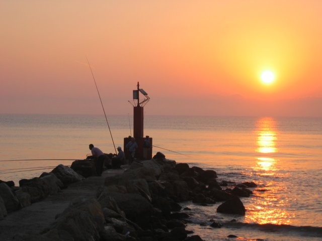 Vissen op de pier bij zonsopgang.