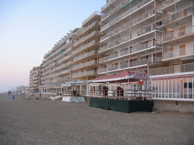 Dit verlaten strand kan tippen aan de Belgische kust. De hotels staan op het strand. Er is bijna geen verharde wandelstrook tussen de hotels en het strand.