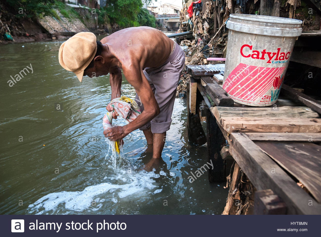 A man washes a towel on the Ciliwung River in Bukit Duri area, Jakarta, Indonesia. (Alamy Stock Photo, Reynold Sumayku , July 5, 2009)