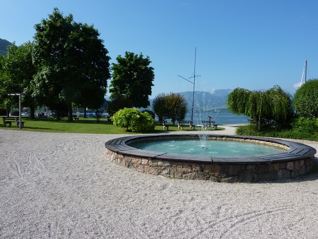 Zugang zum öffentlichen Badeplatz mit Springbrunnen, Liegewiese und Steg