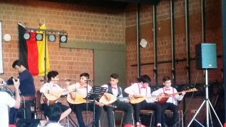 Die Jungs spielen ein türkisches Musikstück mit dem Saiteninstrument Saz, ähnlich einer Laute