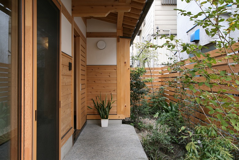 植栽と杉板塀に囲まれた玄関（植栽・外構は彩苑）