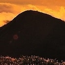 schwarzer Berg vor orangenem Himmel  