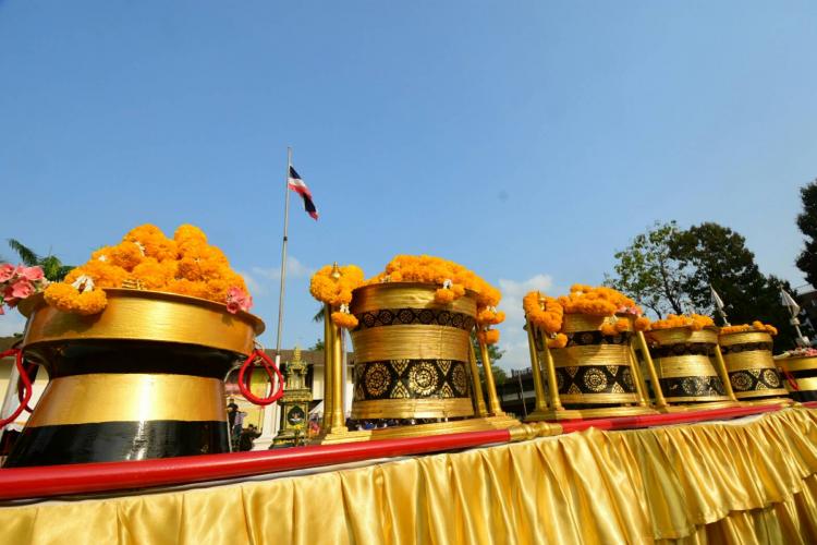 Flower offerings on drums and national flag in the background.