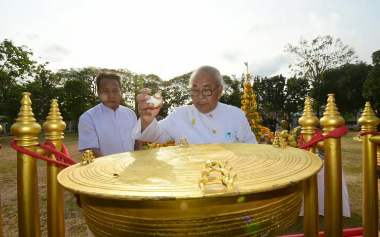 The Brahmin Sishanaphan Rangsiprahmanakul prepares to pour lustral water on the eardrum of the drum with a waving conch shell.