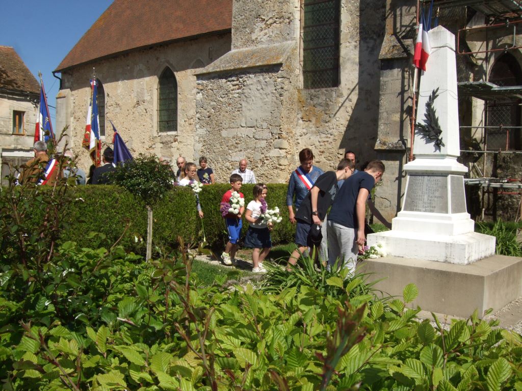 Ils sont accompagnés des enfants du village qui déposent à leur tour, un bouquet confectionné pour l'occasion par la Maire déléguée