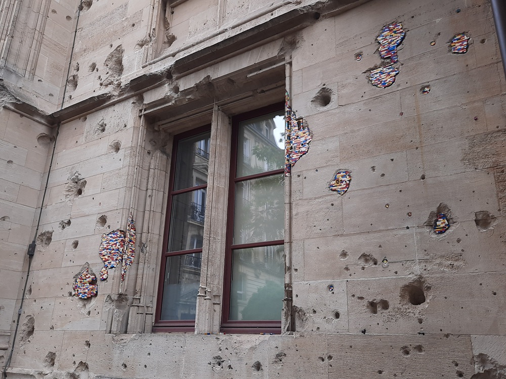 Les traces laissées par les bombardement recouvertes de Legos lors d'une exposition d'art temporaire
