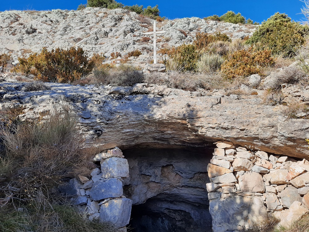 L'entrée de la grotte-chapelle est heureusement surmontée d'une croix blanche qui permet de la voir