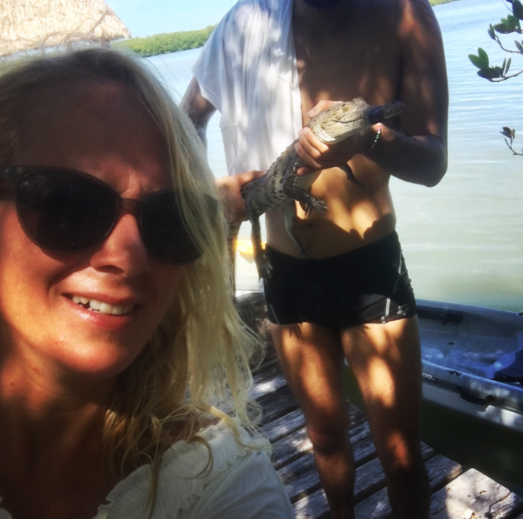Selfie mit einem, der einen kleinen Alligator hält.