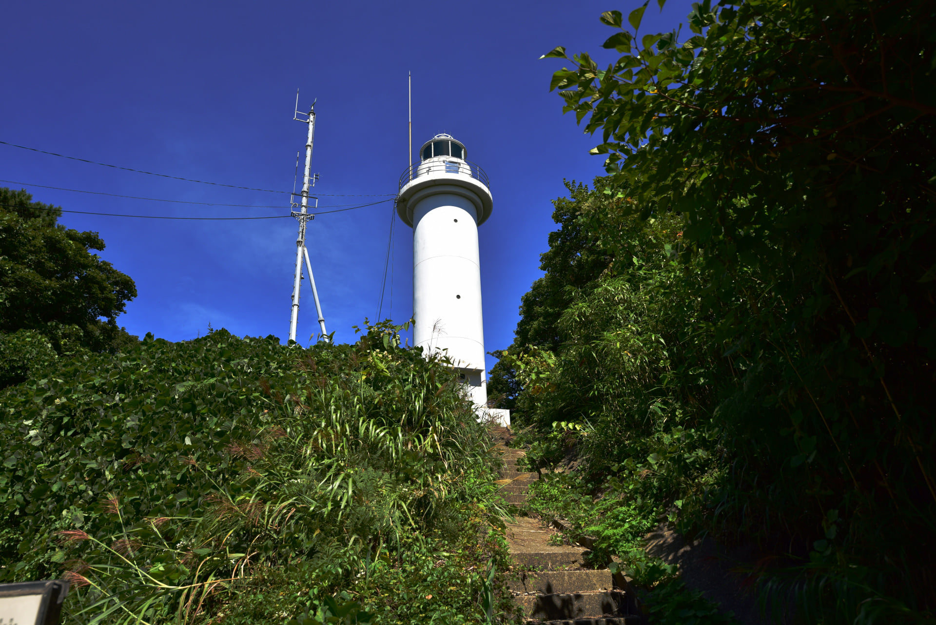 1387 飛島灯台 (山形県)南灯台から１時間で飛島灯台に到着。尾根の上のほぼ平坦な道で15分毎にあるベンチで休憩ができ、思ったより楽に到着。島の反対側の防波堤灯台も撮影し戻る。帰りは流石に惰性で淡々と歩く状態に。1時間前に到着し無事帰還。
