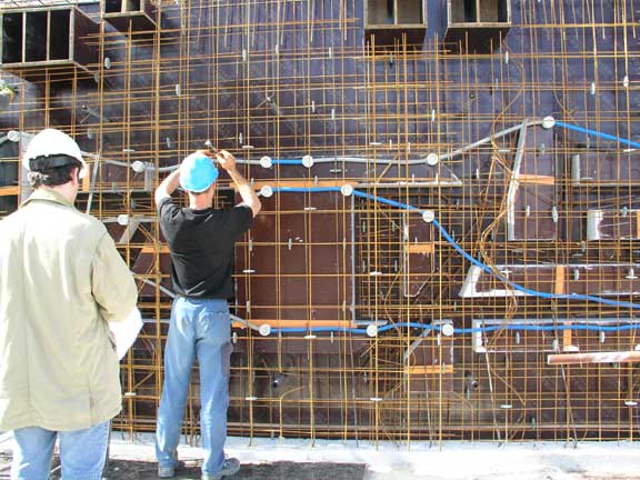 10 - Pendant ce temps, avant de couler les murs en béton, les ouvriers réservent l'emplacement des niches et réalisent le câblage électrique 