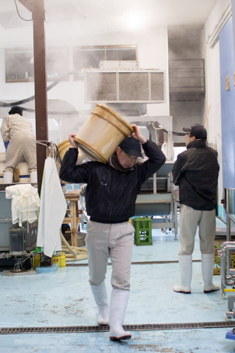 蒸し上がった蒸米を担ぐ高橋靖拡さんが向かう先は・・・？