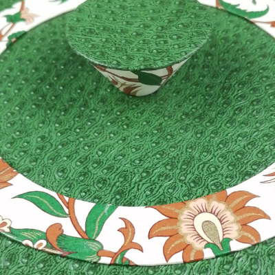 Zoom sur le couvercle de la boite à bijoux ronde avec motif floral et simili cuir vert