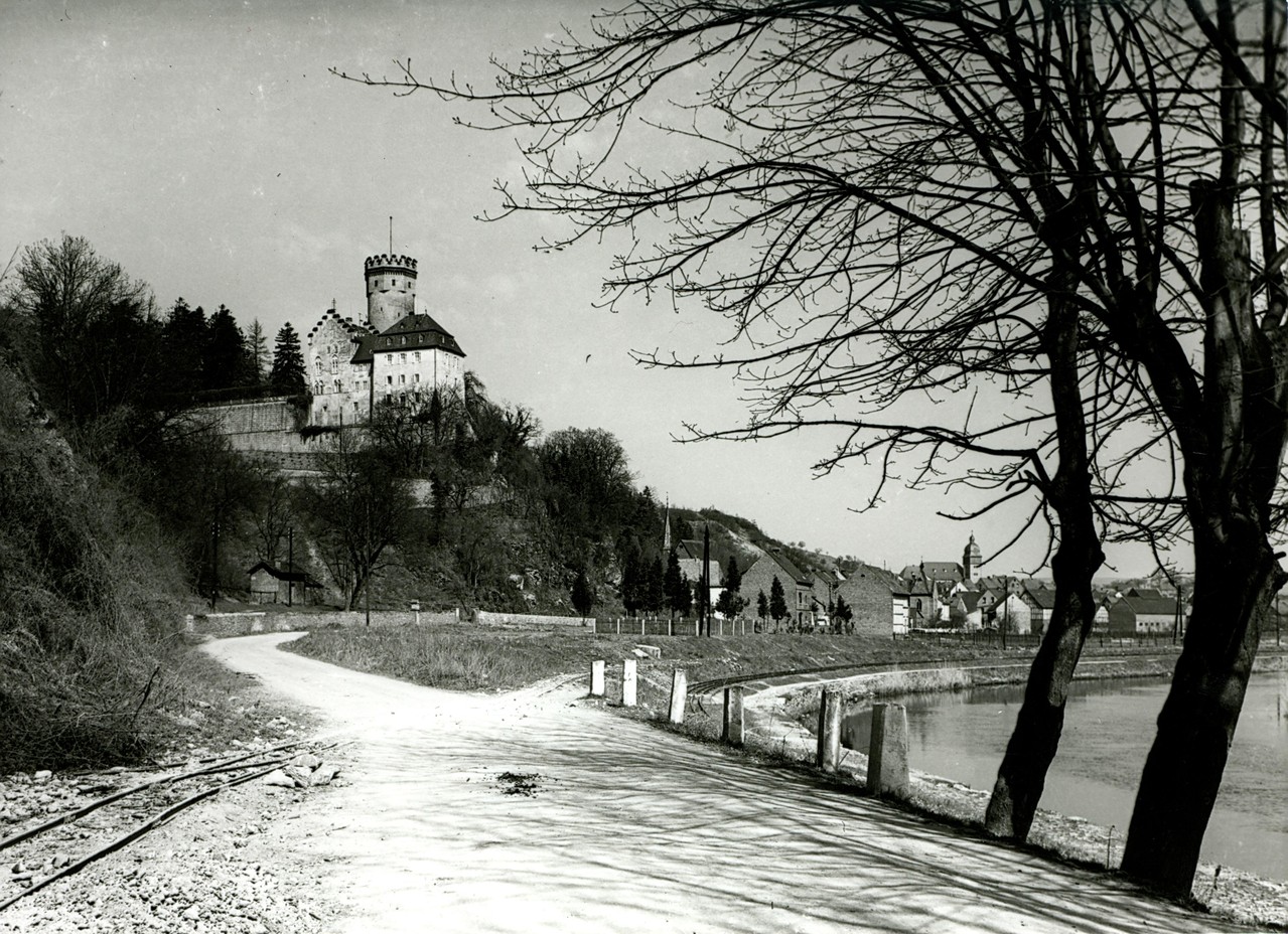 Ortseingang Dehrn, ähnlicher Blickwinkel, die Feldbahn kreuzt die Straße zum Steinbruch