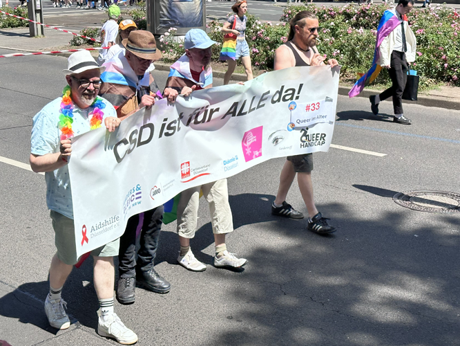 Gruppe von "Queer im Alter" mit Banner "CSD ist für ALLE da!"