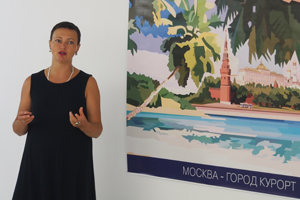 Bild: Kuratorin Natalia Gershevskaya erläutert das Plakat "Moscow – city resort" von Kostantin Latyshev