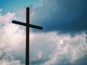 Kirchenkreuz vor dunklem Wolkenhimmel