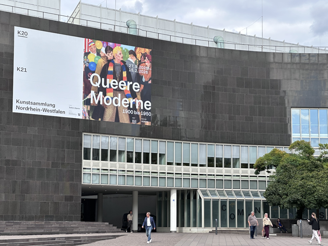 Eingang des Museums K20 in Düsseldorf mit einer großen Werbefassade für die Ausstellung 'Queere Moderne – 1900 bis 1950.