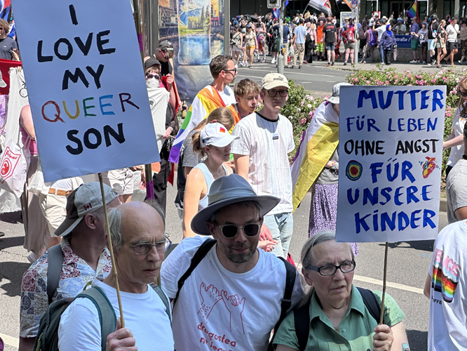 Teilnehmende mit Plakat "I love my queer Son"