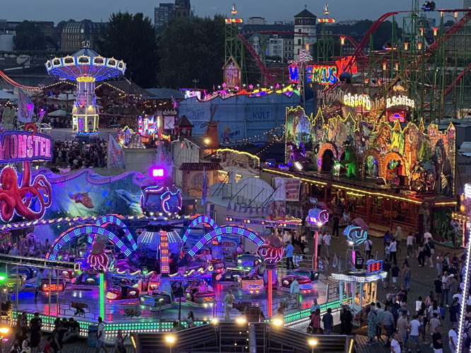 Blick auf die Düsseldorfer Rheinkirmes mit bunt beleuchteten Fahrgschäften