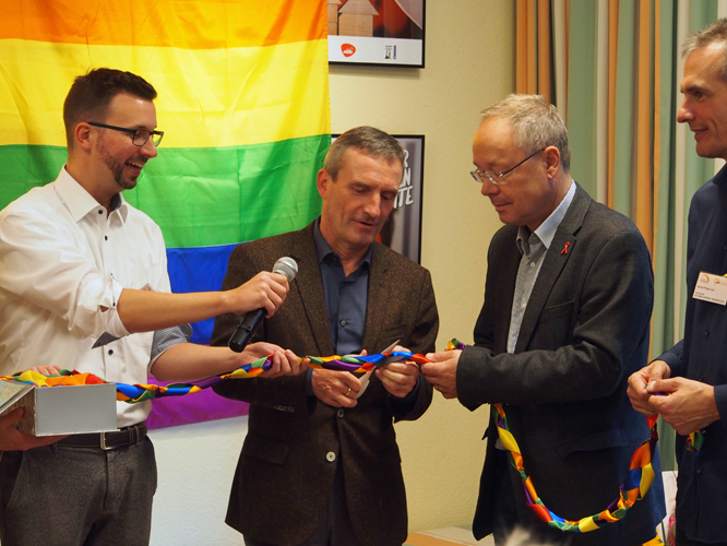 Bild: OB Thomas Geisel zerschneidet das Band zum Start der Fachstelle "Altern unterm Regenbogen"