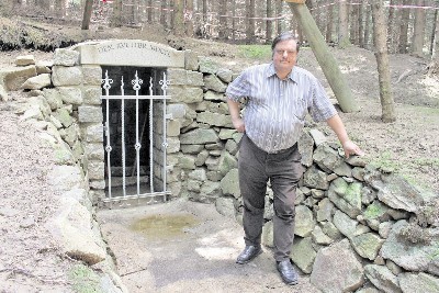 Harald Körner steht vor dem restaurierten Mundloch des Erbstollens bei Steinigtwolmsdorf. Foto: Wolfgang Schmidt