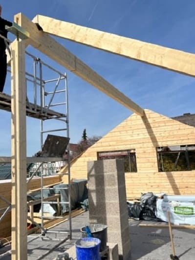 Montage des Firstbalkens vom Wohnblockhaus 