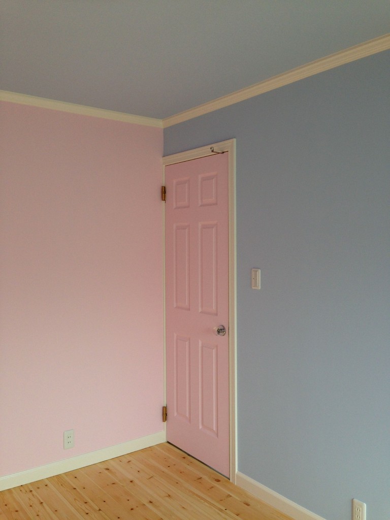 リビング横の子ども室。ピンクとライトブルーの壁。ドアはピンクで。