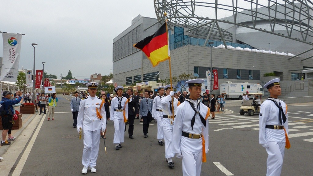 Die deutsche Delegation auf dem Weg zum Hissen der deutschen Fahne anlässlich des NationentagesDie deutsche Delegation auf dem Weg zum Hissen der deutschen Fahne anlässlich des Nationentages