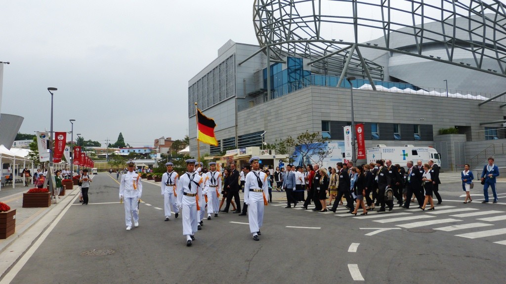 Die deutsche Delegation auf dem Weg zum Hissen der deutschen Fahne anlässlich des Nationentages