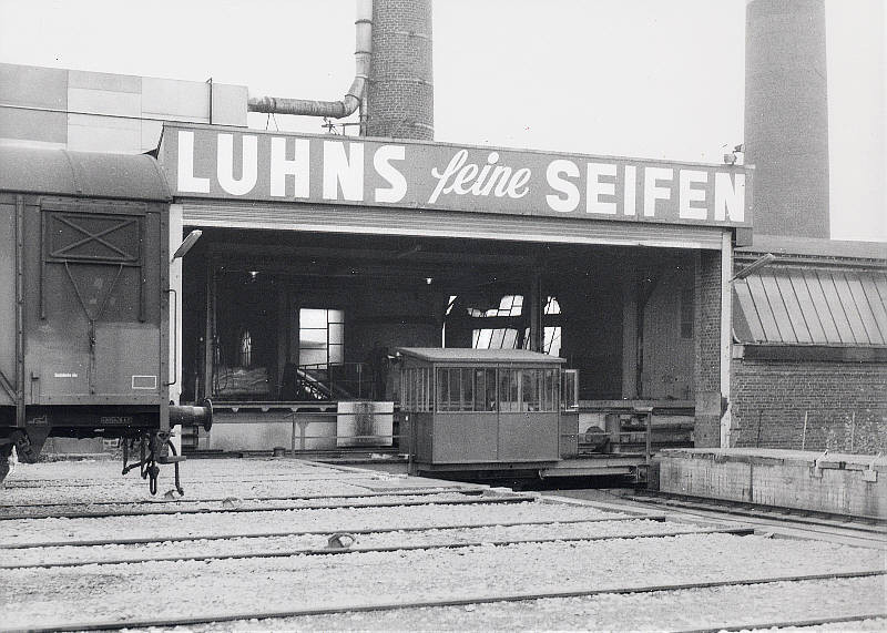Ein Werkfoto der Firma Luhns aus der Sammlung VOBA aus ähnlicher Perspektive. Der gedeckte Güterwagen steht im Abholgleis des Anschlusses. Das Foto stammt aus Mitte der 1970er Jahre.
